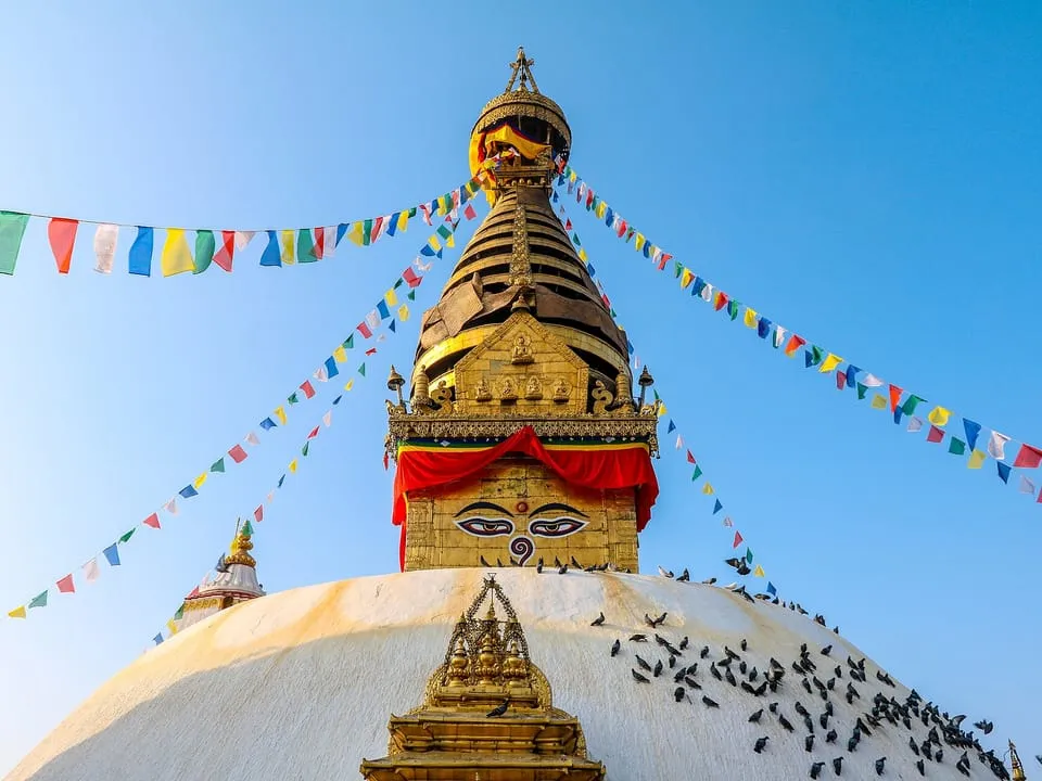 The golden spire of Swayambhunath stupa hung with prayer flags