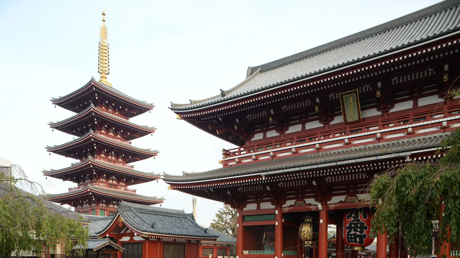 The red five-storied pagoda of Senso-ji with its golden spire beside the Hozomon Gate and its large red lantern in Asakusa
