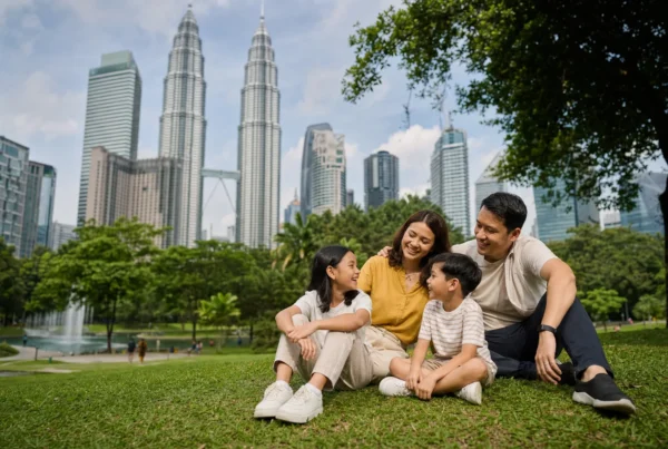 A family relaxing in KLCC Park with the Petronas Twin Towers behind them