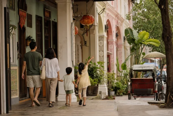 A family walking beside heritage shophouses in George Town, Penang