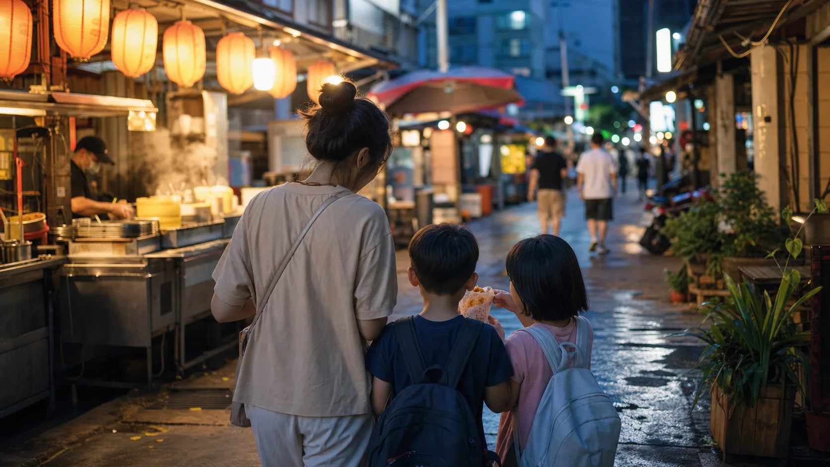 A parent and two children exploring a Taipei night market at blue hour